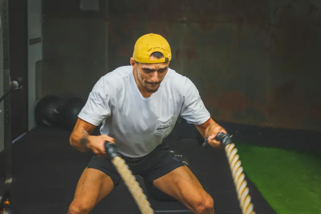 Man in White Crew Neck T-shirt doing training using Ropes